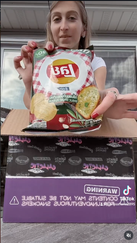 Customer opening a Galactic Snacks box with garlic bread Lay's in an Instagram post